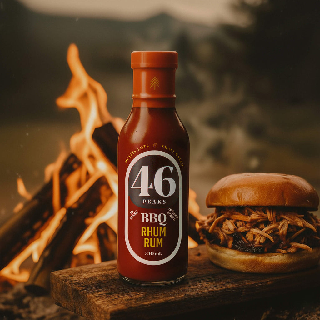 Bottle of 46 Peaks BBQ Rhum Rum with a burger by a campfire